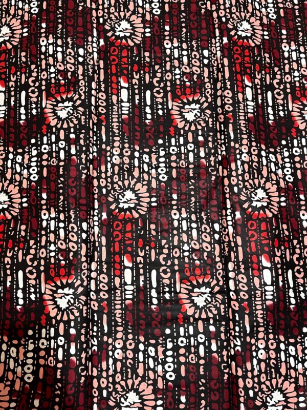 Textile with a pattern of red, black, and beige floral designs on a dark background