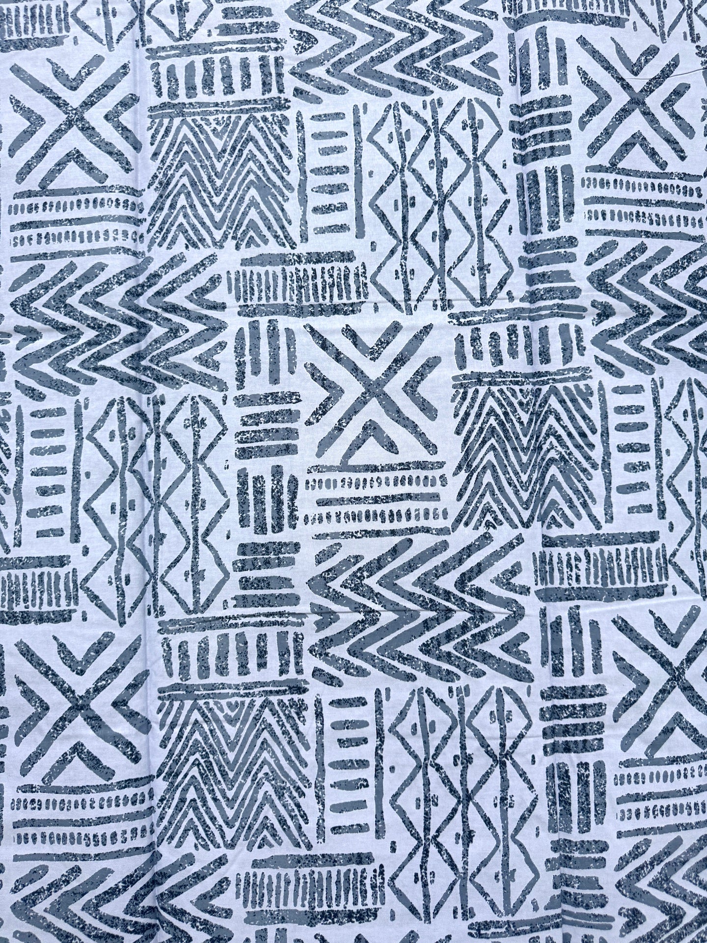 Patterned fabric with blue geometric designs on a light blue background
