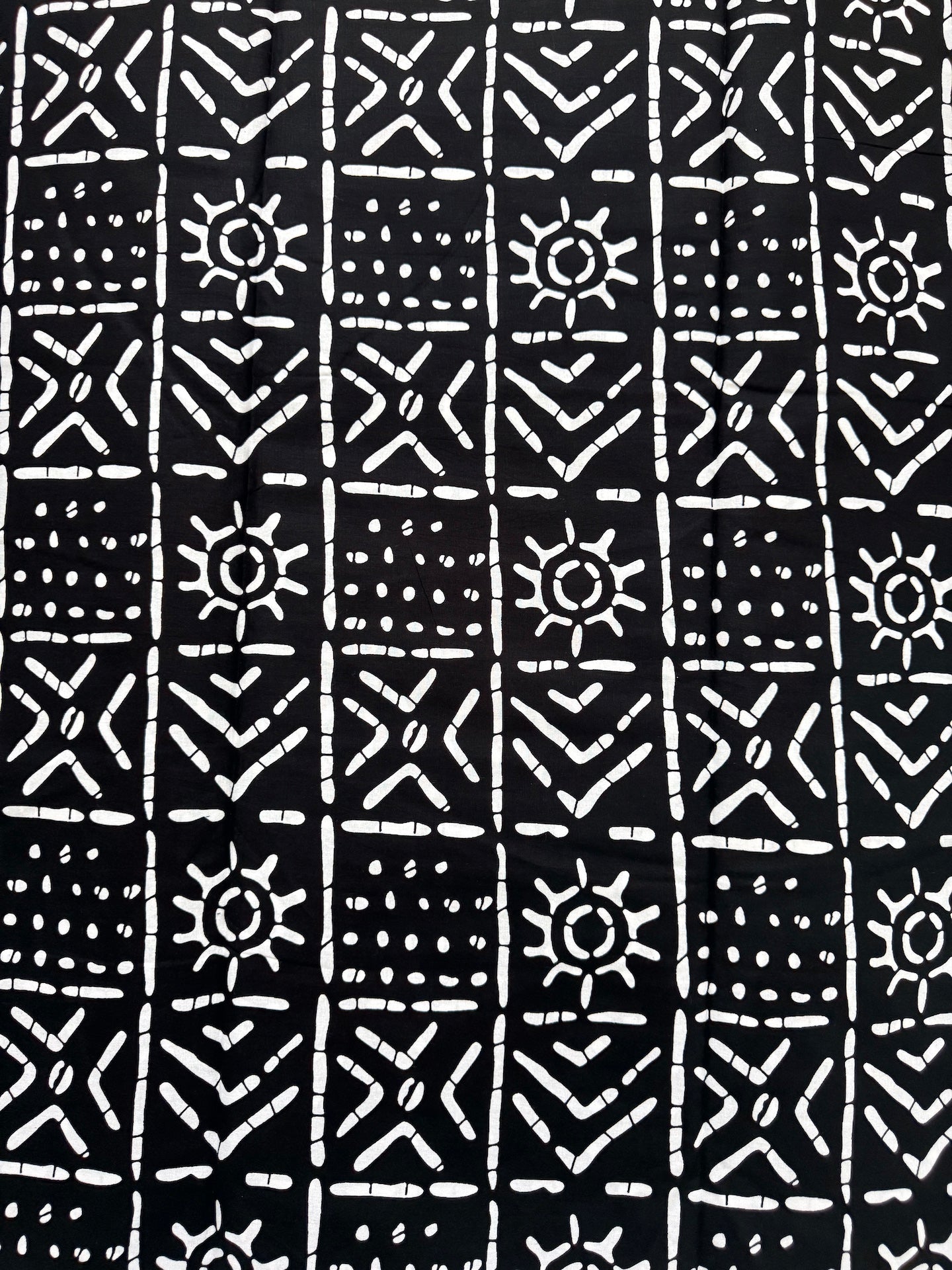 Black and white geometric pattern with sun shapes on a black background