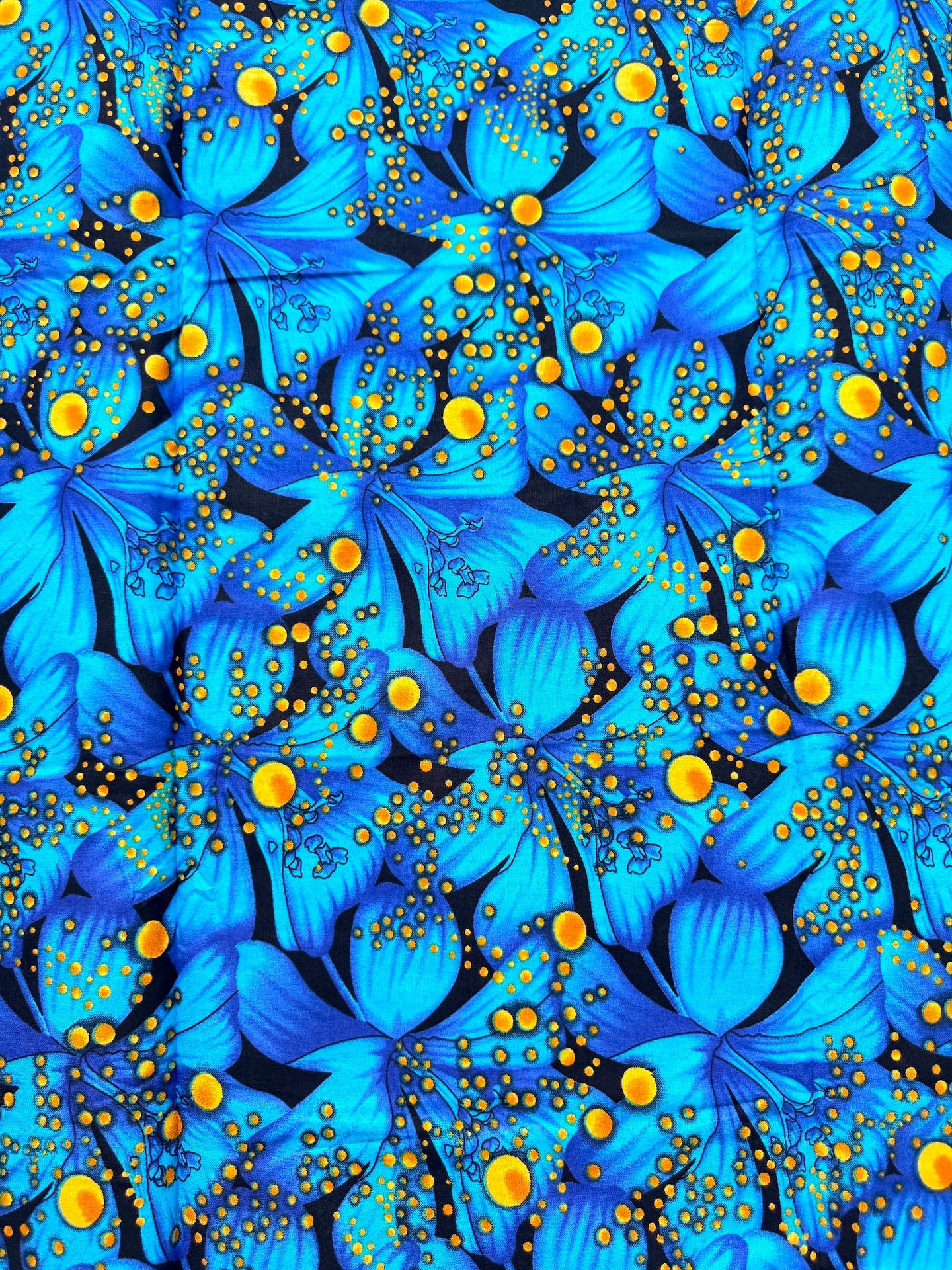 Pattern of blue flowers with yellow centers on a black background