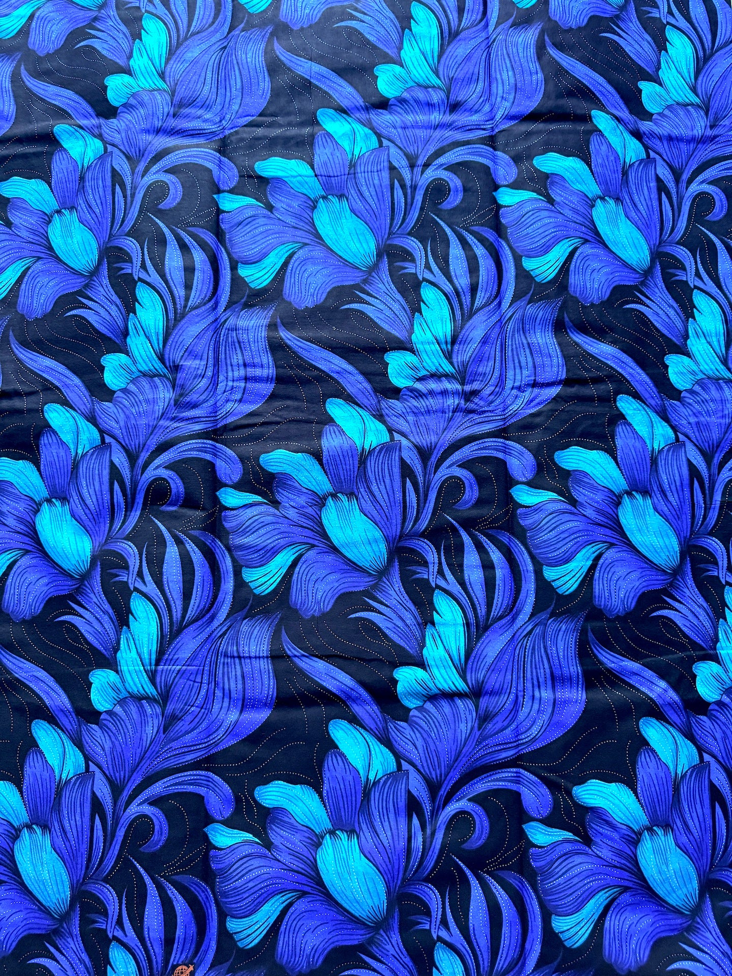 A close-up of a fabric or wallpaper pattern featuring stylized blue and turquoise floral motifs on a very dark navy background.