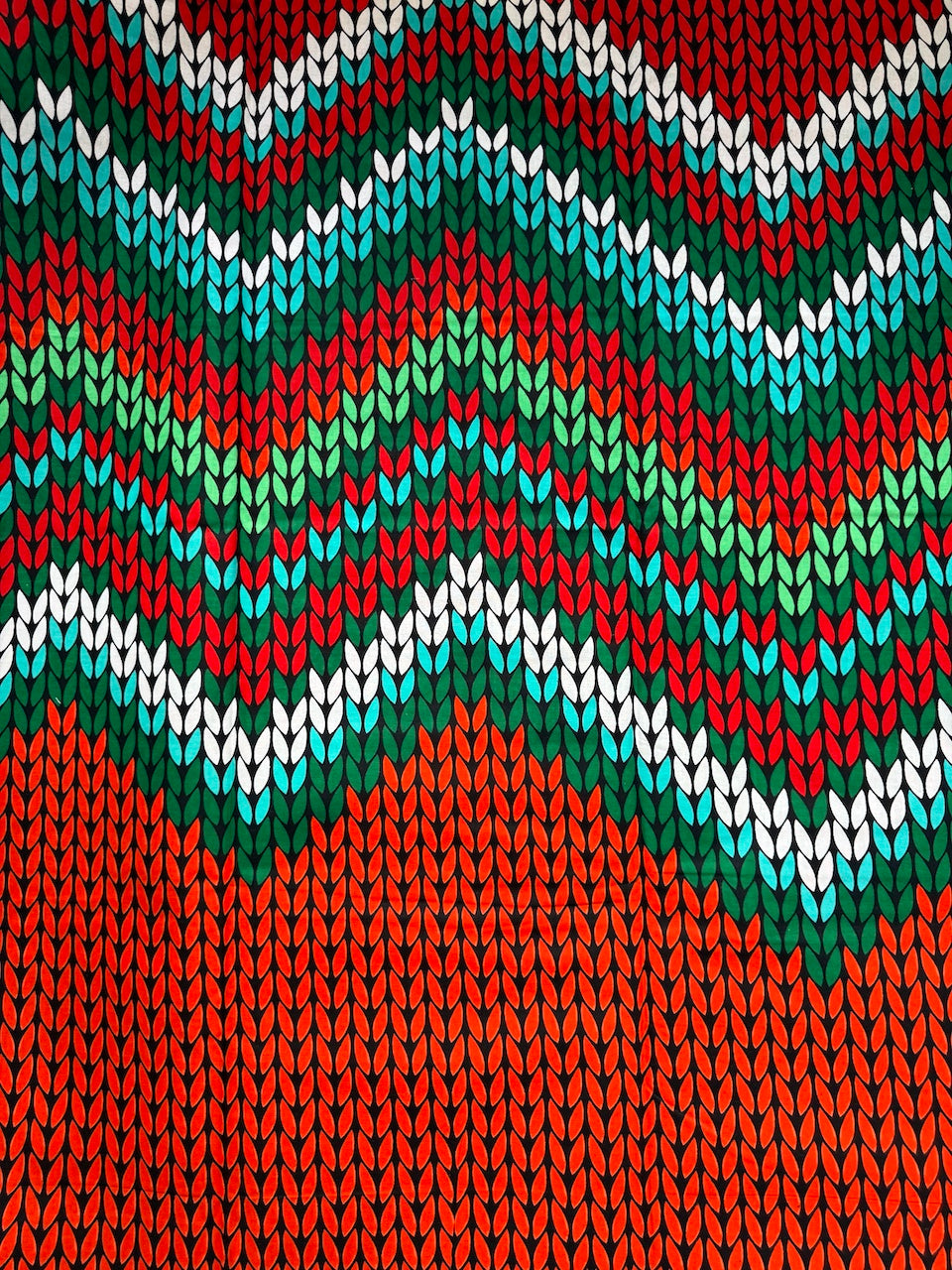 Knitted fabric with a colorful zigzag pattern in red, green, blue, and white.