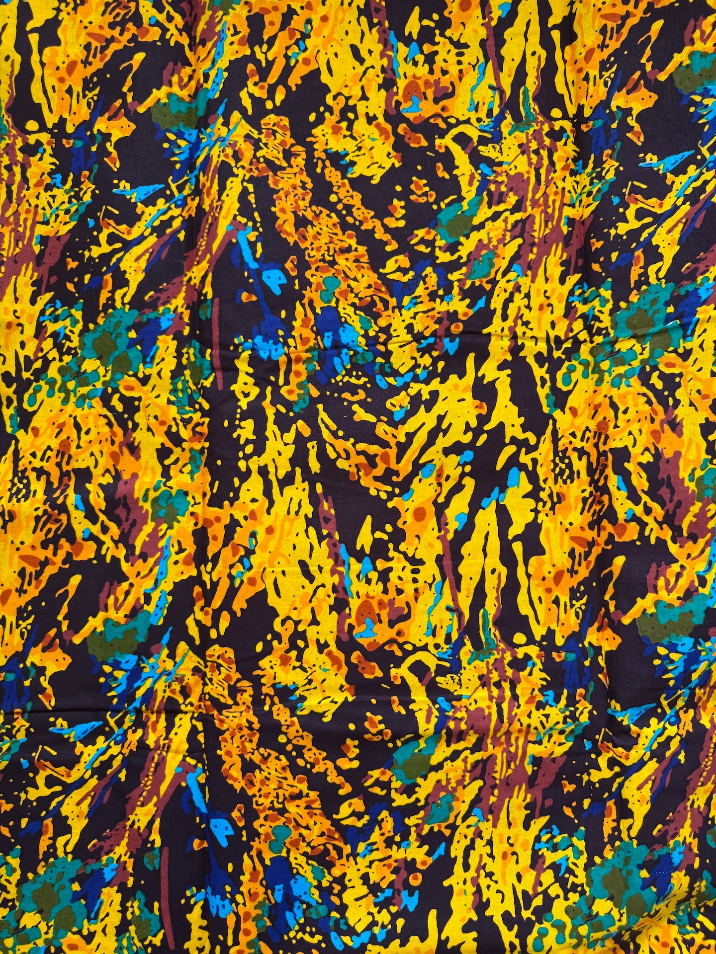 Abstract art with splashes of yellow, blue, and black on a textured background