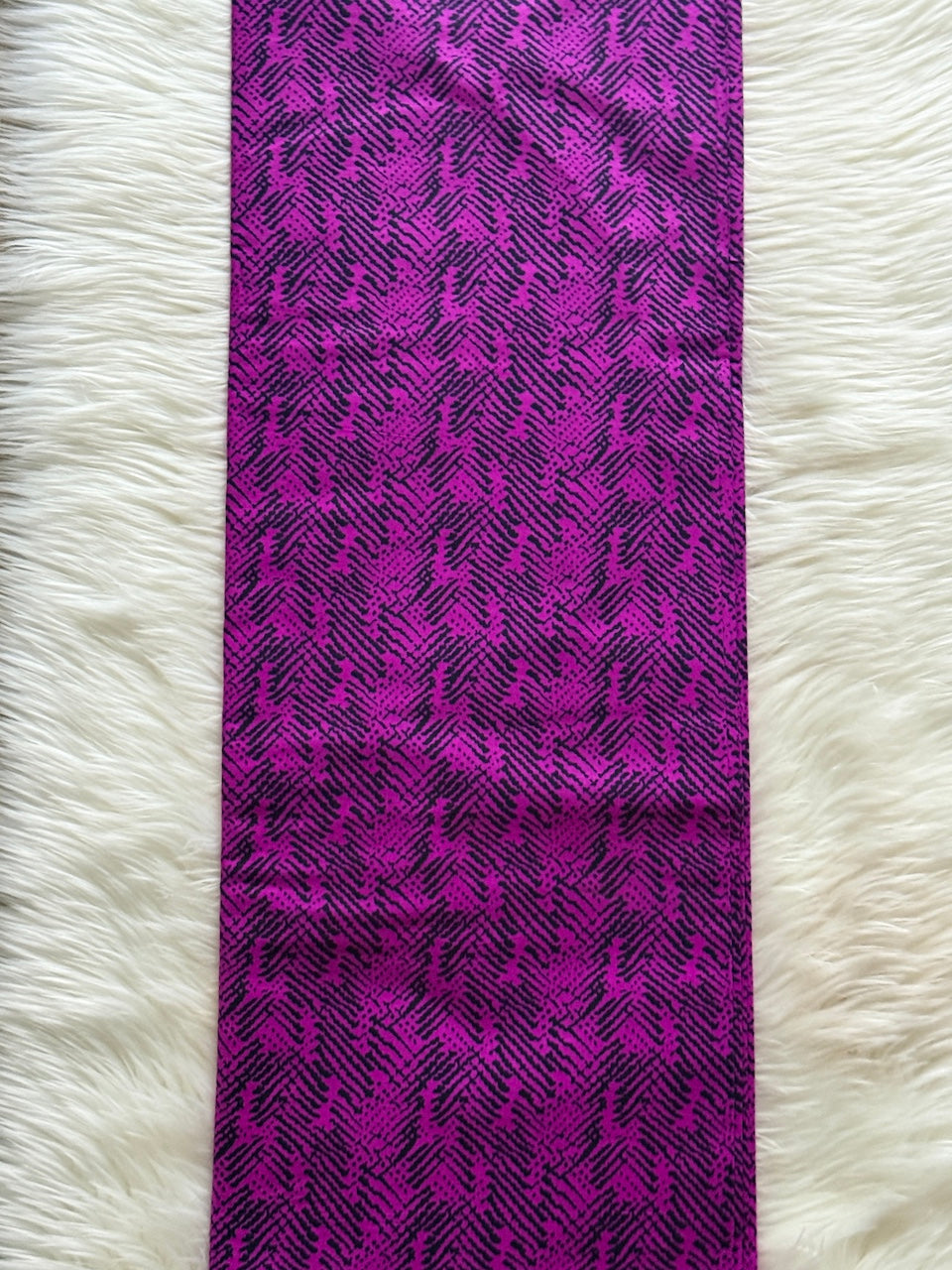 Purple patterned fabric on a white fluffy surface
