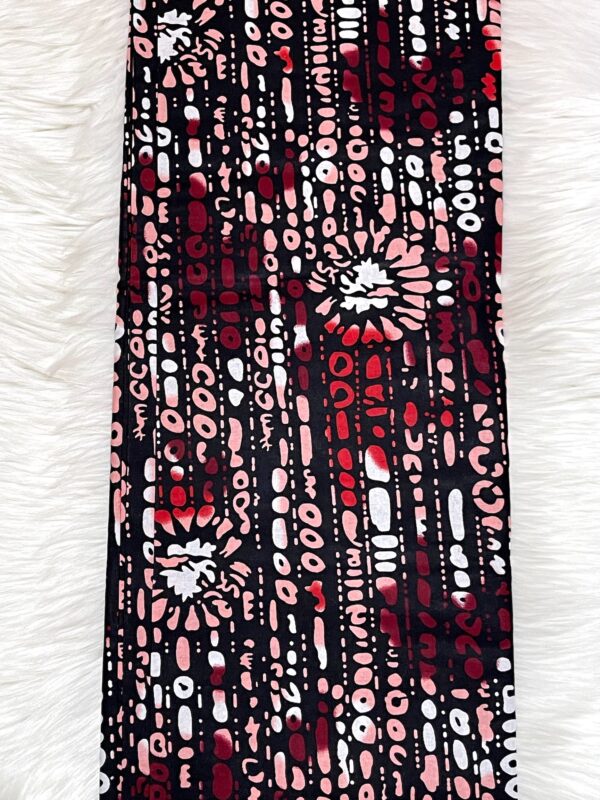 Patterned fabric with red, pink, and white design on a white background