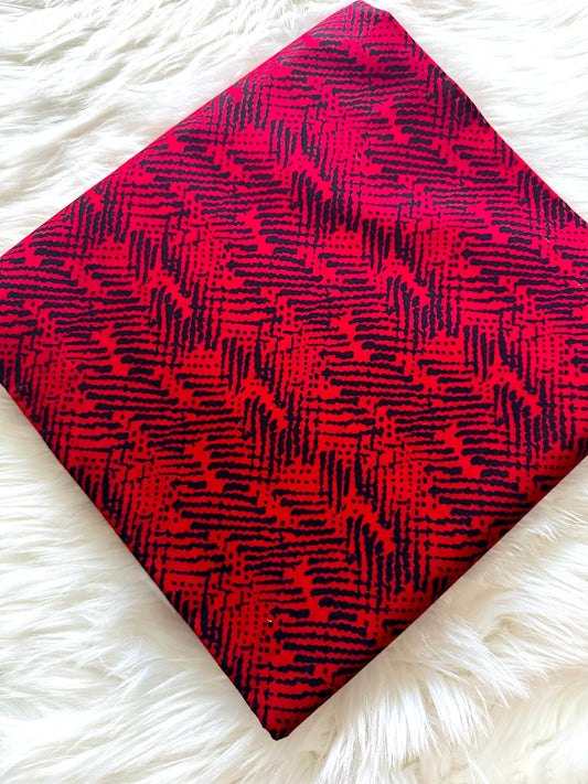 Red and black patterned fabric on a white fluffy surface