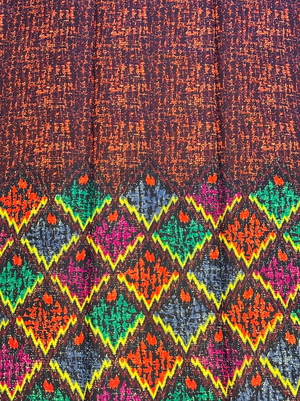 Close-up of a fabric with a multicolored geometric pattern on a dark background