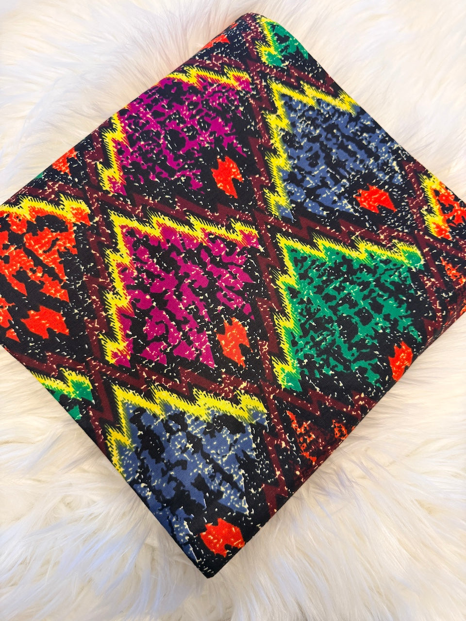 Colorful patterned fabric on a white textured surface