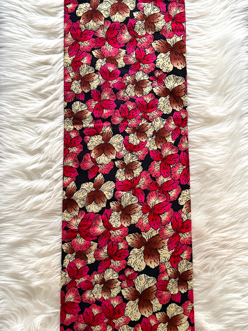 Floral patterned fabric strip on a white textured background