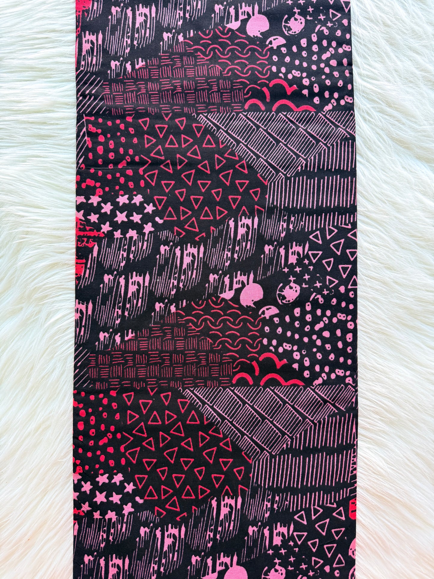 Fabric with pink and black geometric pattern on a white background