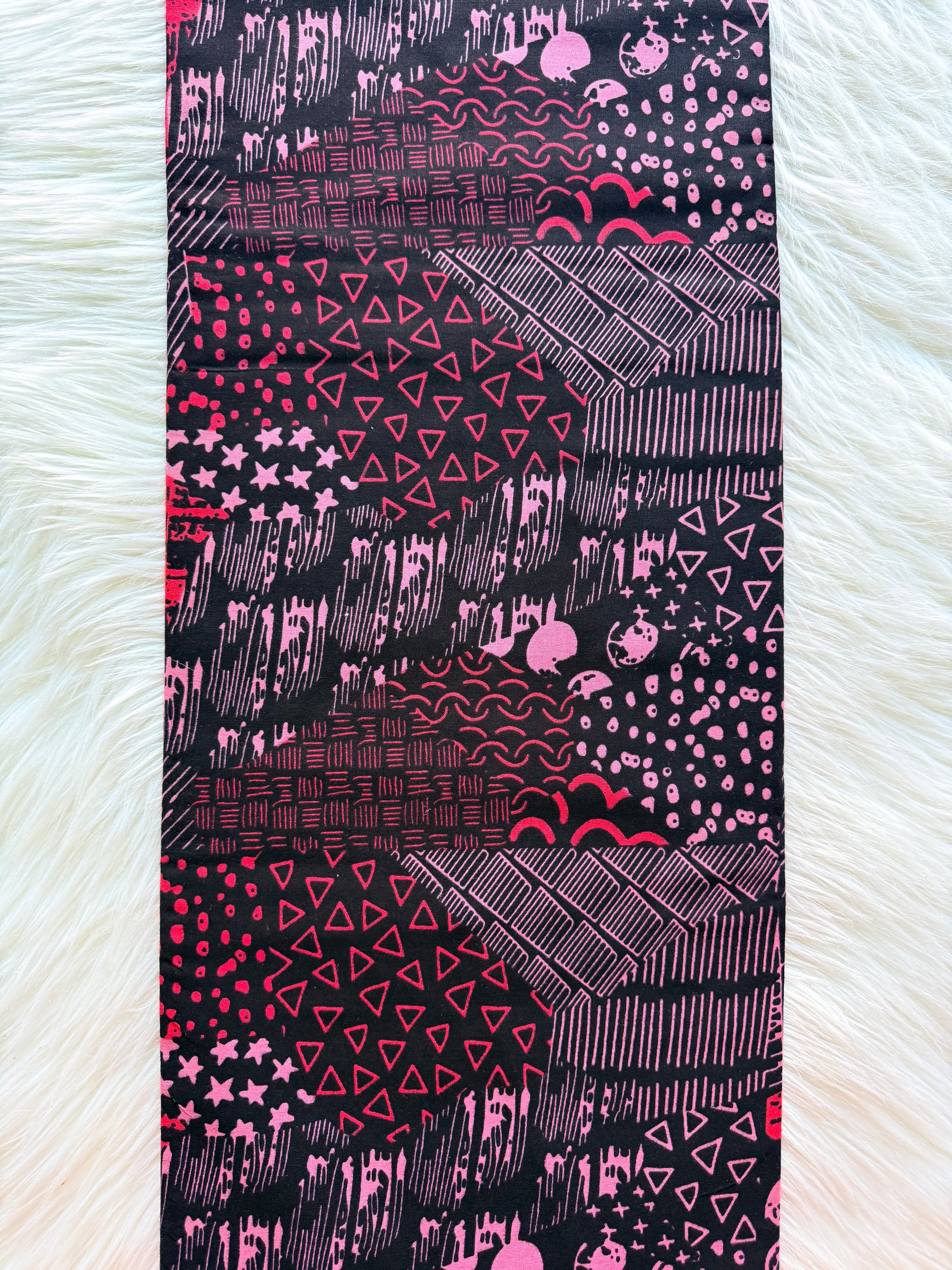 Fabric with pink and black geometric pattern on a white background
