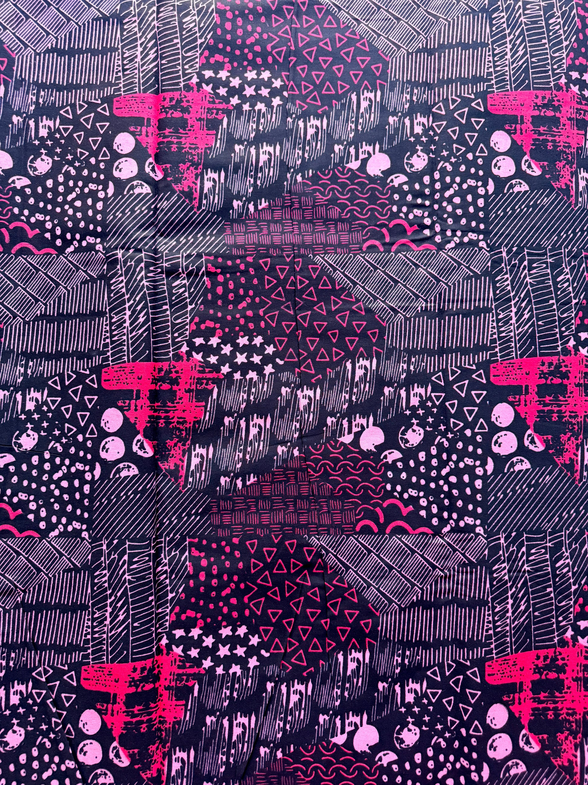 Patterned fabric with pink and black geometric designs on a purple background