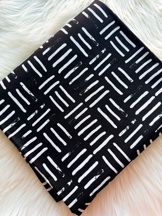 Black notebook with white line pattern on a fluffy white surface