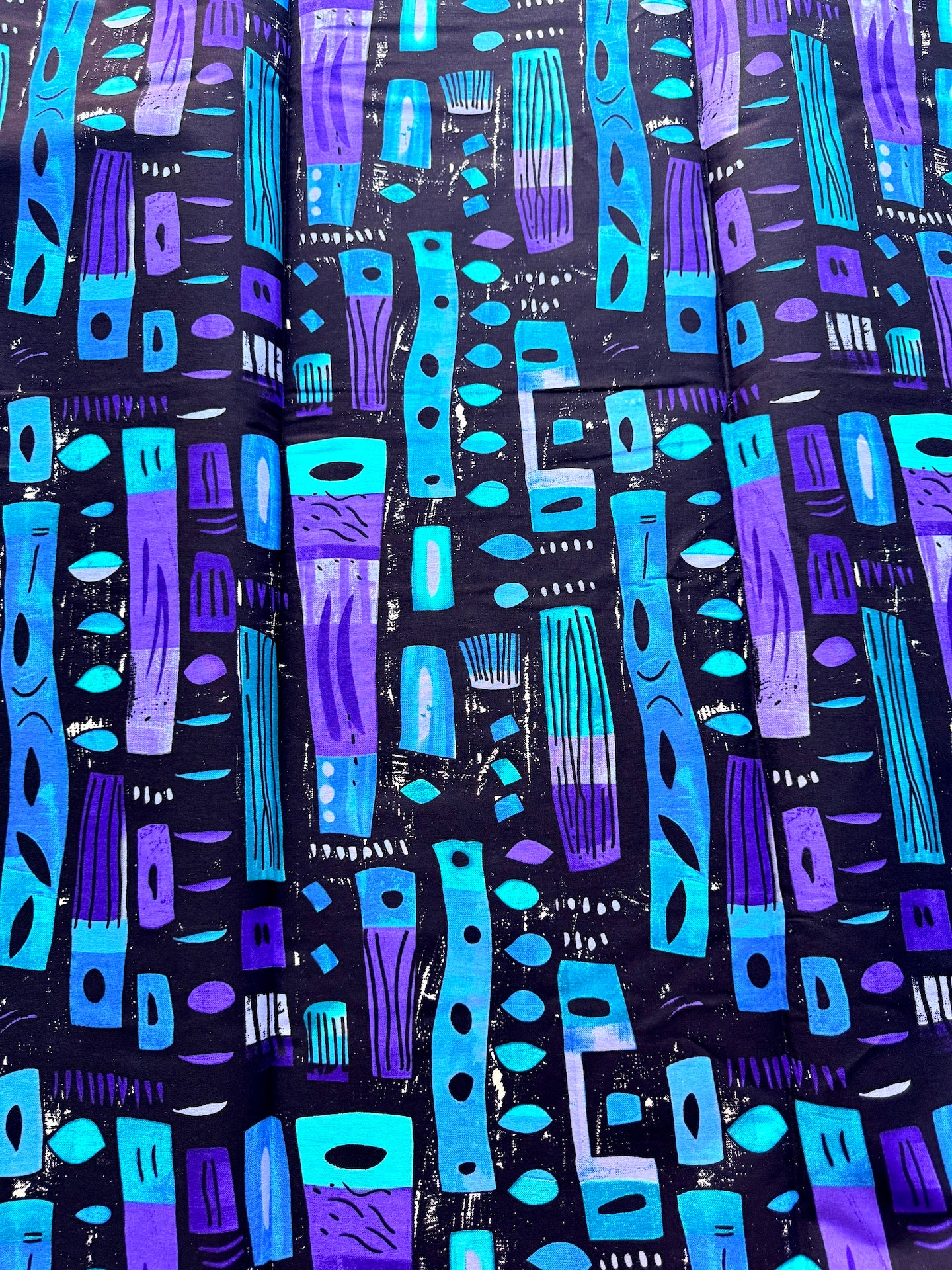 Patterned fabric with blue and purple shapes on a black background