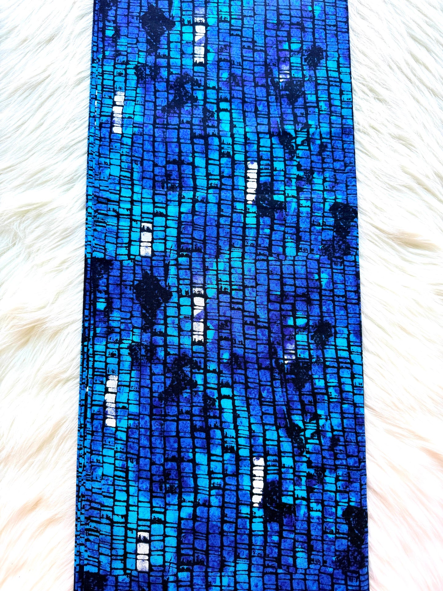 Blue beaded bracelet on a white fur background