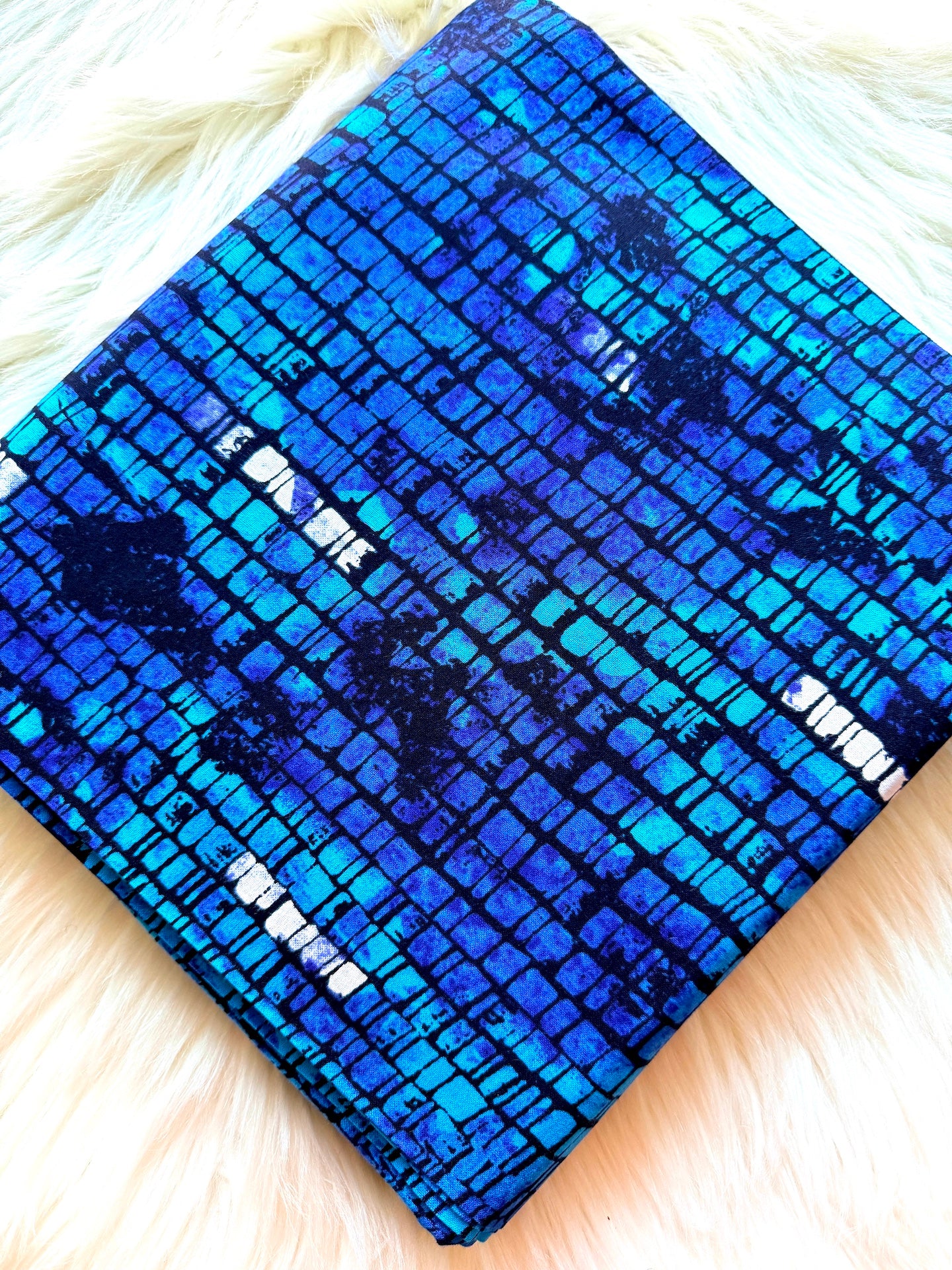 Blue patterned fabric on a white fur surface