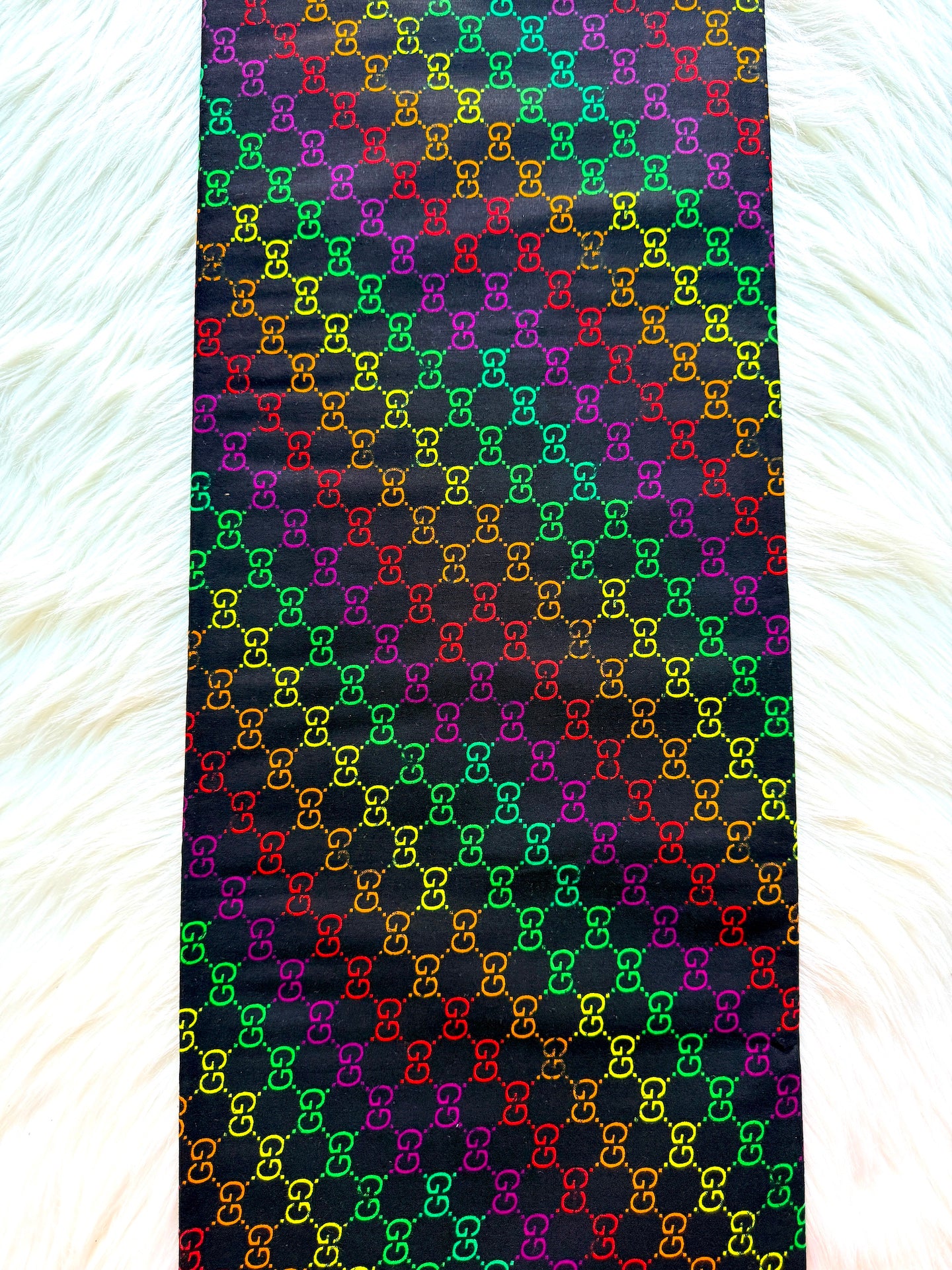 Colorful patterned fabric with a rainbow design on a black background