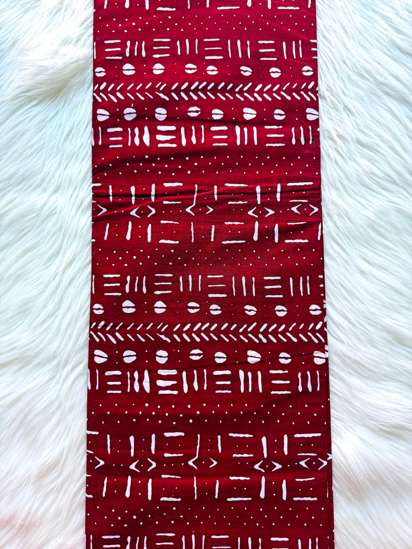 Red patterned fabric on a white fur background