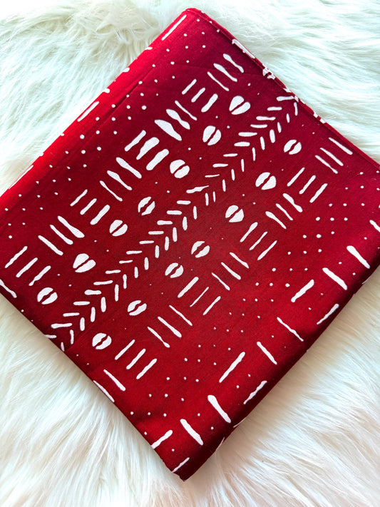 Red fabric with white patterns on a fluffy white surface