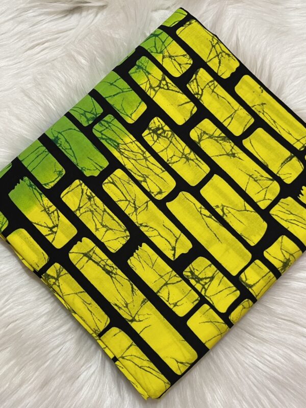 Fabric with yellow and black brick pattern on a white fluffy surface
