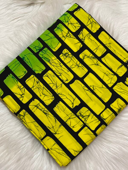 Fabric with yellow and black brick pattern on a white fluffy surface
