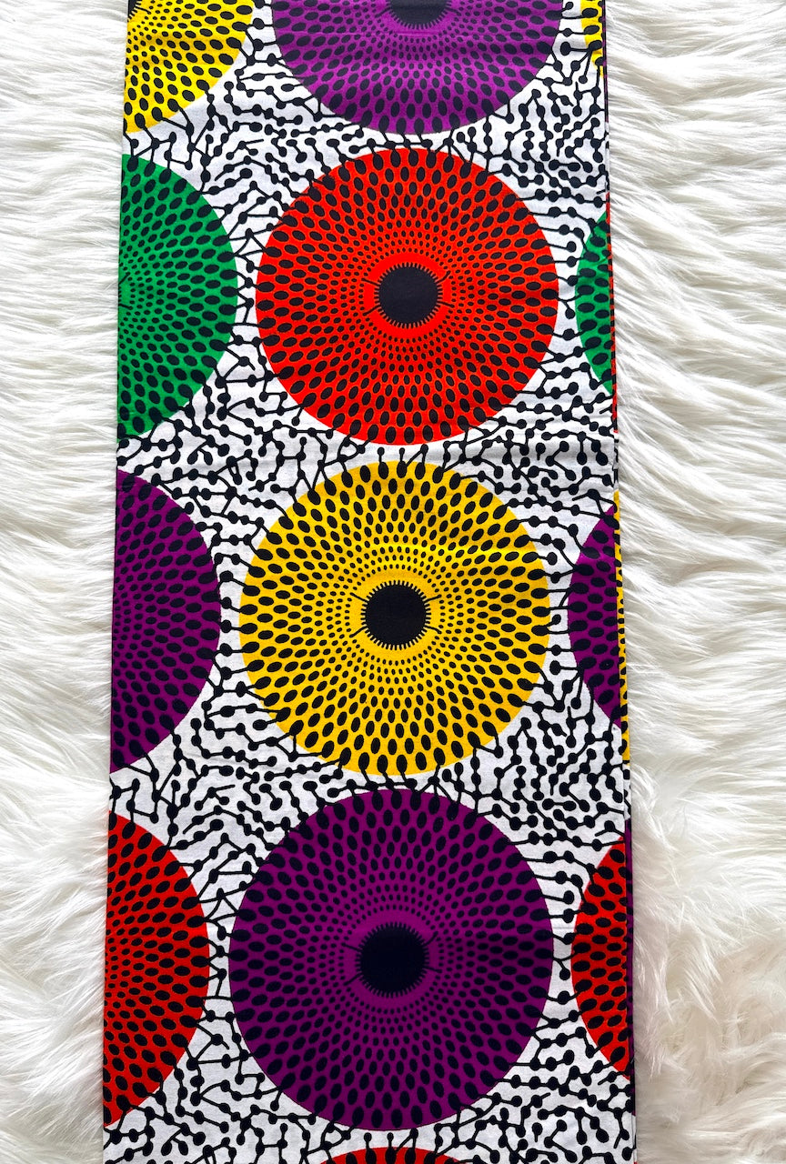 Colorful circular patterned fabric on a white textured background