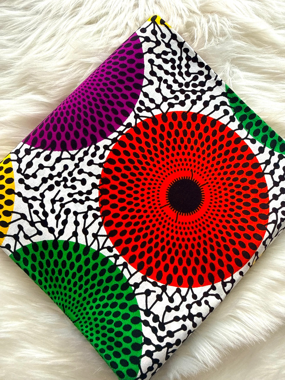 Colorful fabric with geometric patterns on a white fluffy surface