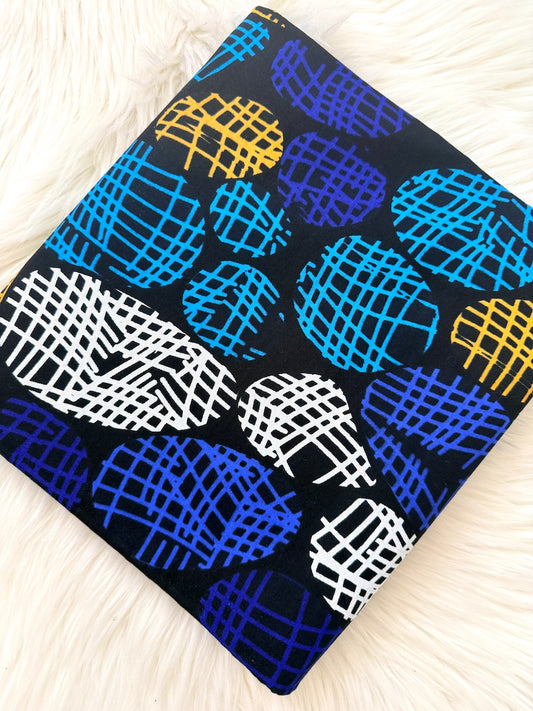 Fabric with blue, yellow, and white abstract patterns on a black background