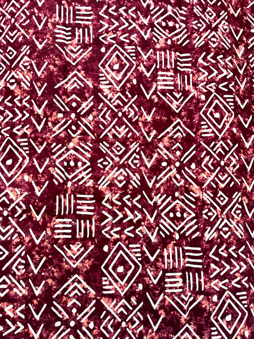 Patterned fabric with geometric design on a red background