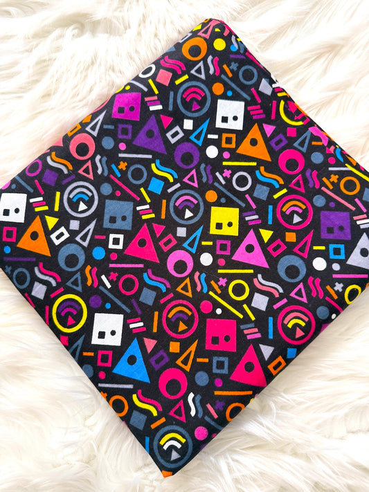 Colorful geometric patterned blanket on a white fluffy surface