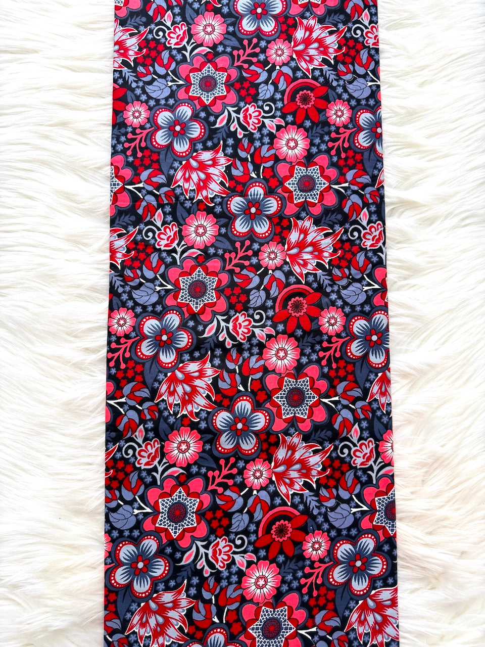Floral patterned fabric with red and blue flowers on a white fluffy surface