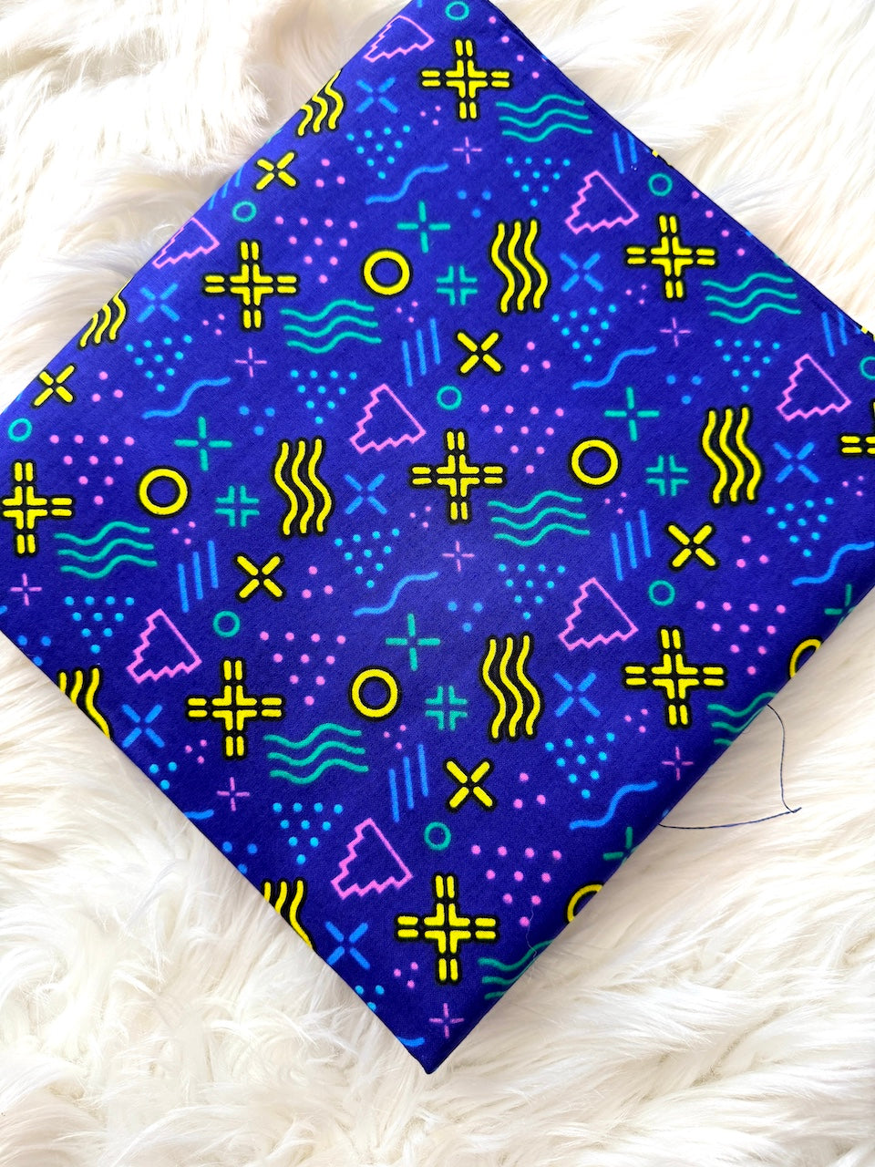 Colorful geometric patterned fabric on a white fluffy surface