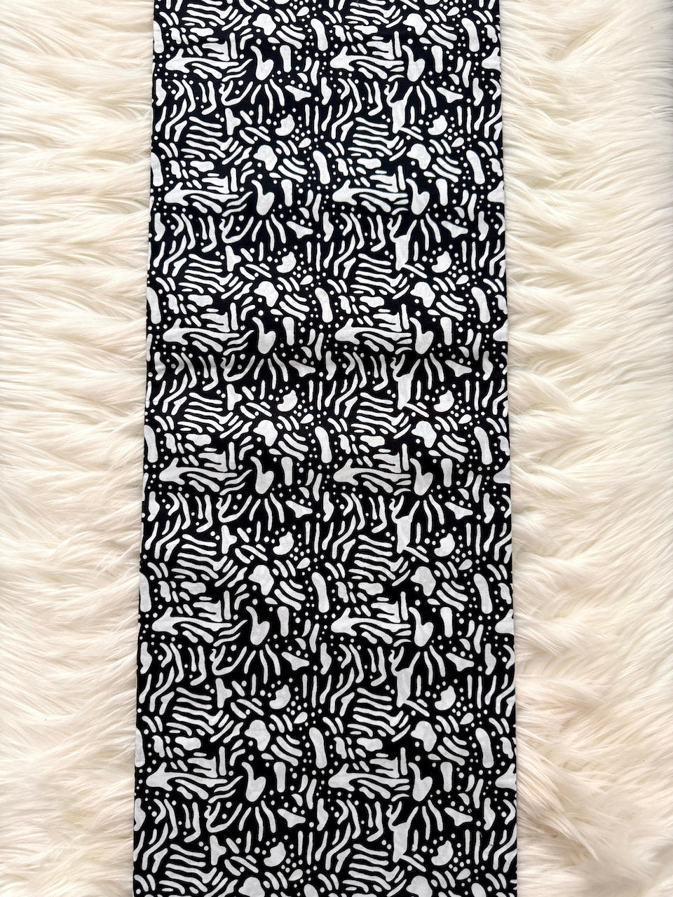 Black and white patterned fabric on a textured white surface