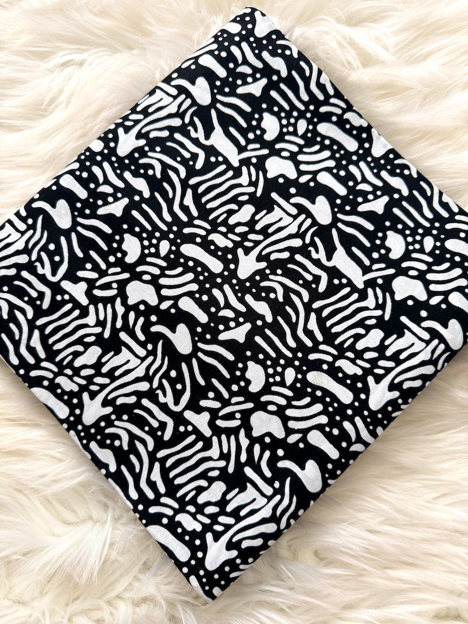 Black and white patterned fabric on a fluffy white surface