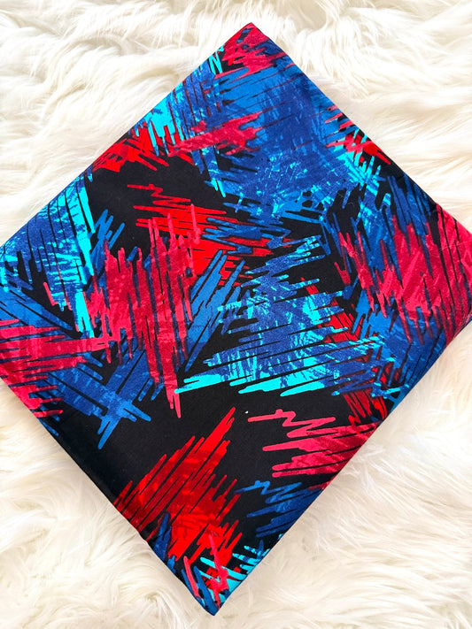 Colorful abstract patterned fabric on a white fluffy surface