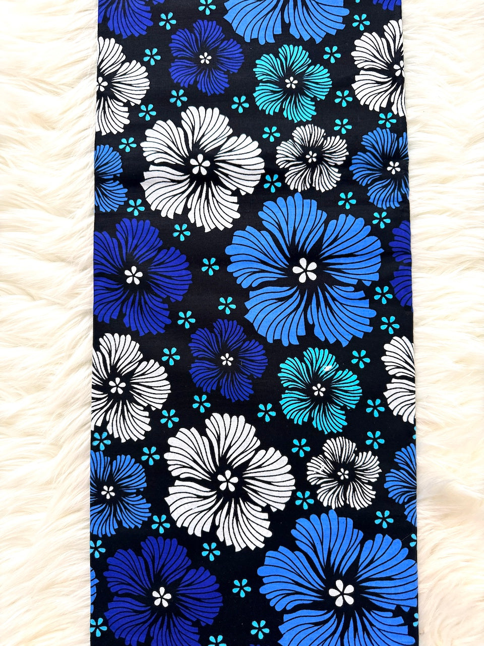Fabric with blue and white floral pattern on a black background
