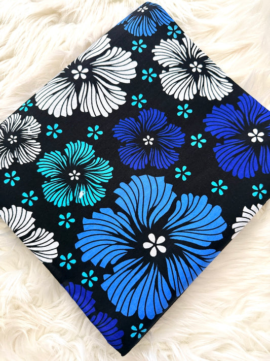 Floral patterned fabric with blue, white, and turquoise flowers on a black background.