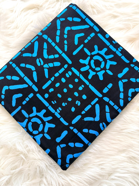 Black fabric with blue geometric pattern on a white fluffy surface
