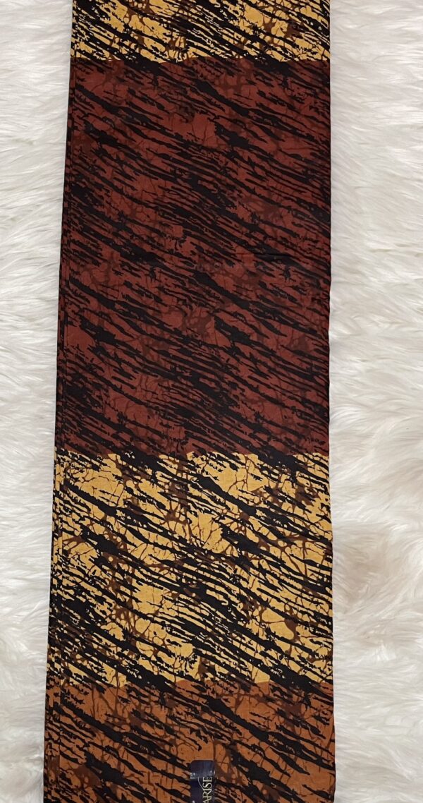 Patterned tie with brown, black, and gold colors on a textured white background