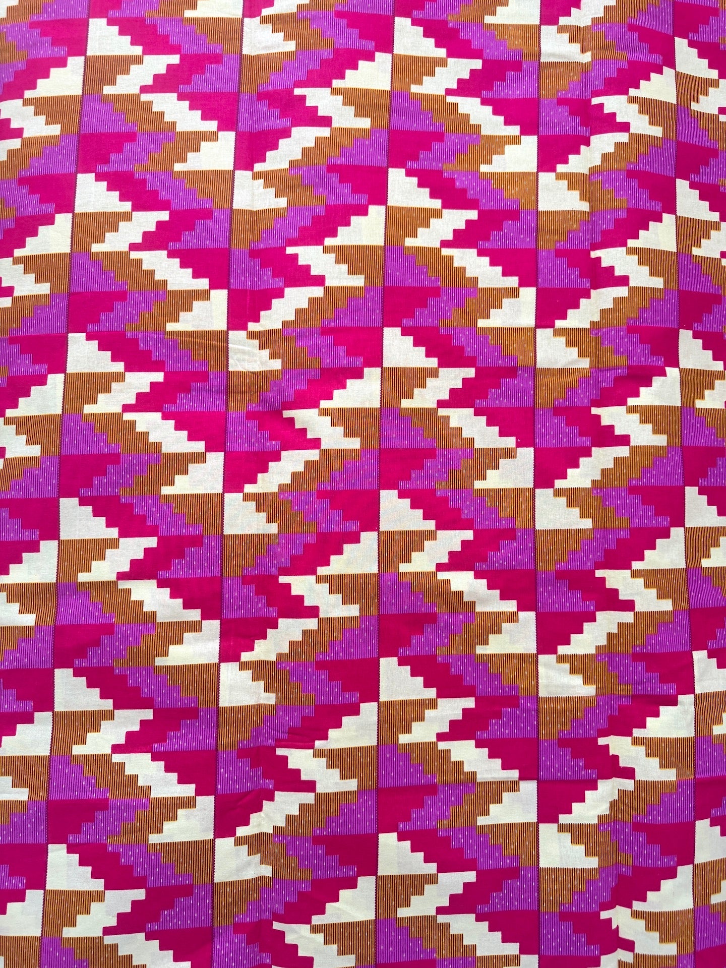 Patterned fabric with a zigzag design in pink, purple, and brown.