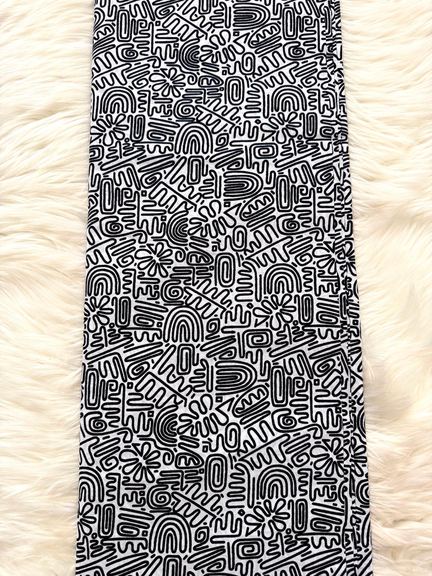 Black and white patterned towel on a fluffy white surface