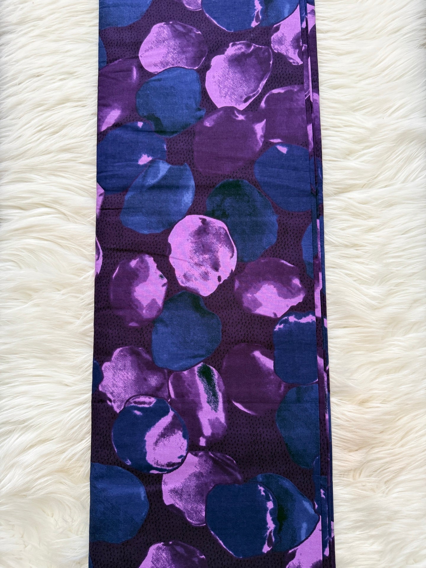 Purple and blue patterned ribbon on a white fluffy surface