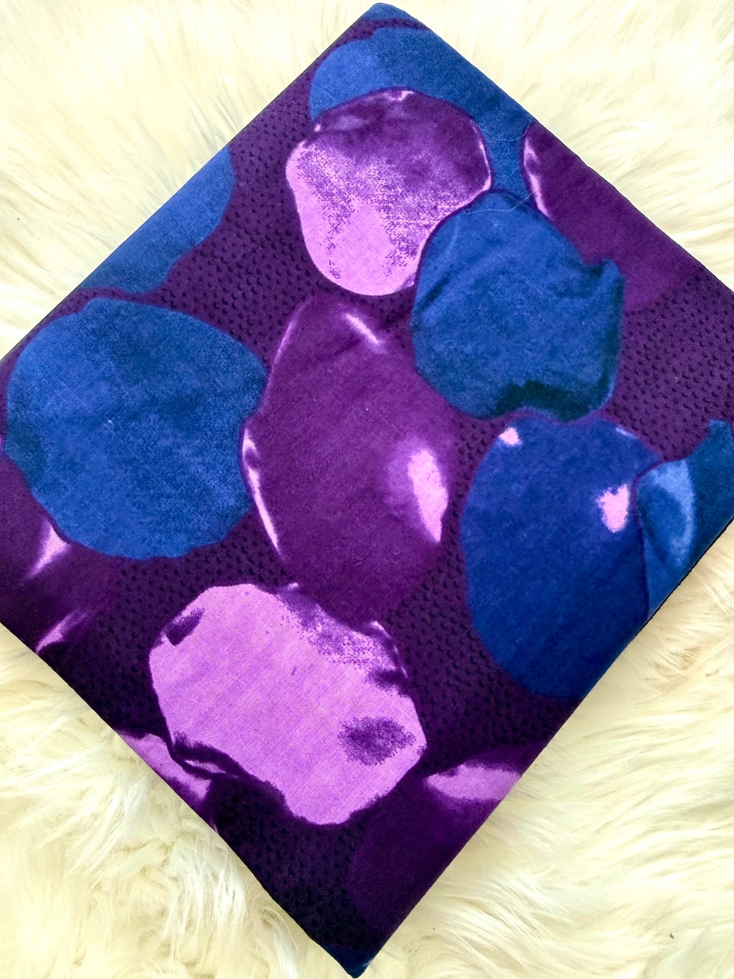 Purple and blue patterned fabric on a textured beige background