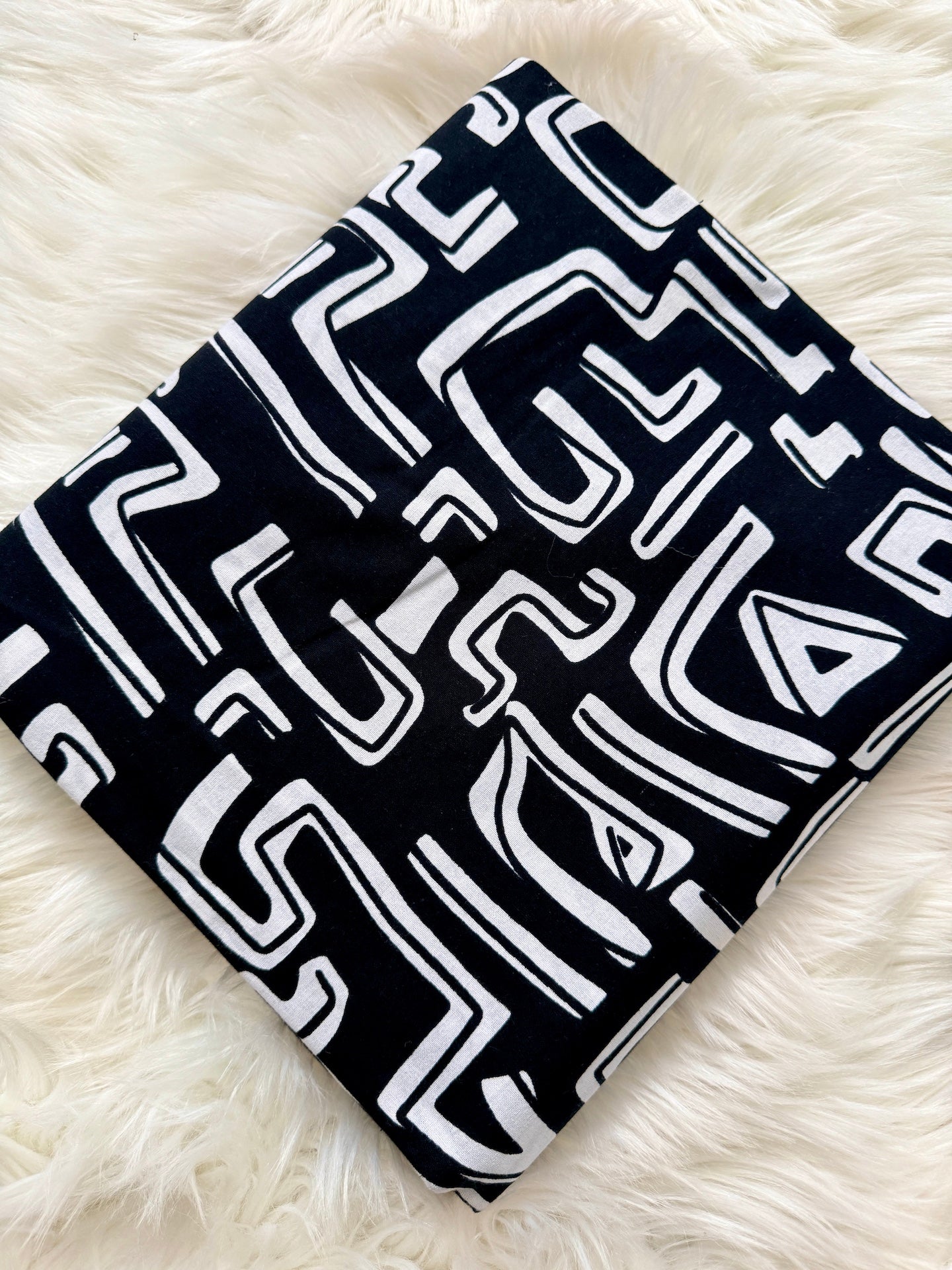 Black and white patterned fabric on a fluffy white surface