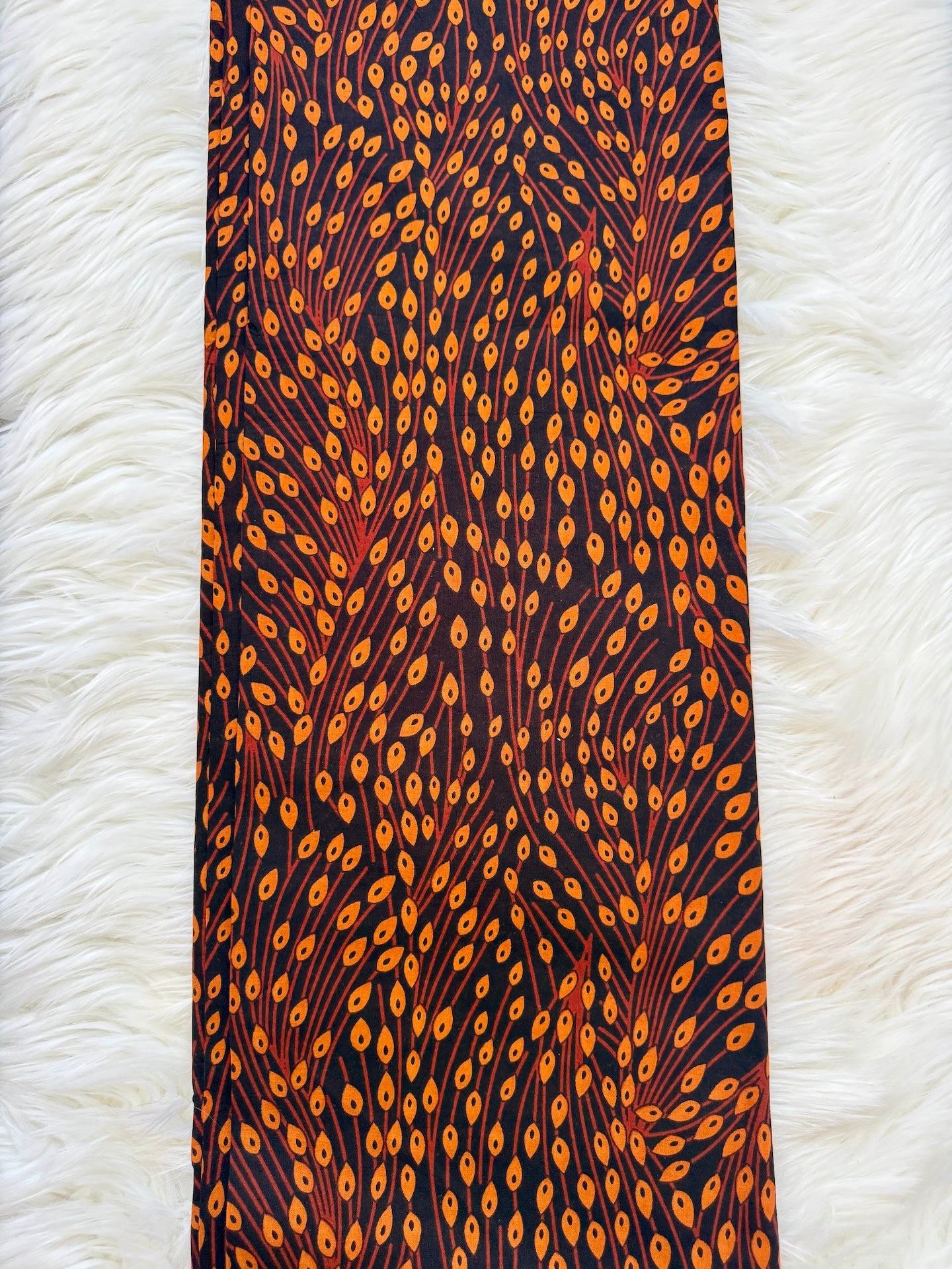 Tie with orange and brown pattern on a white textured background