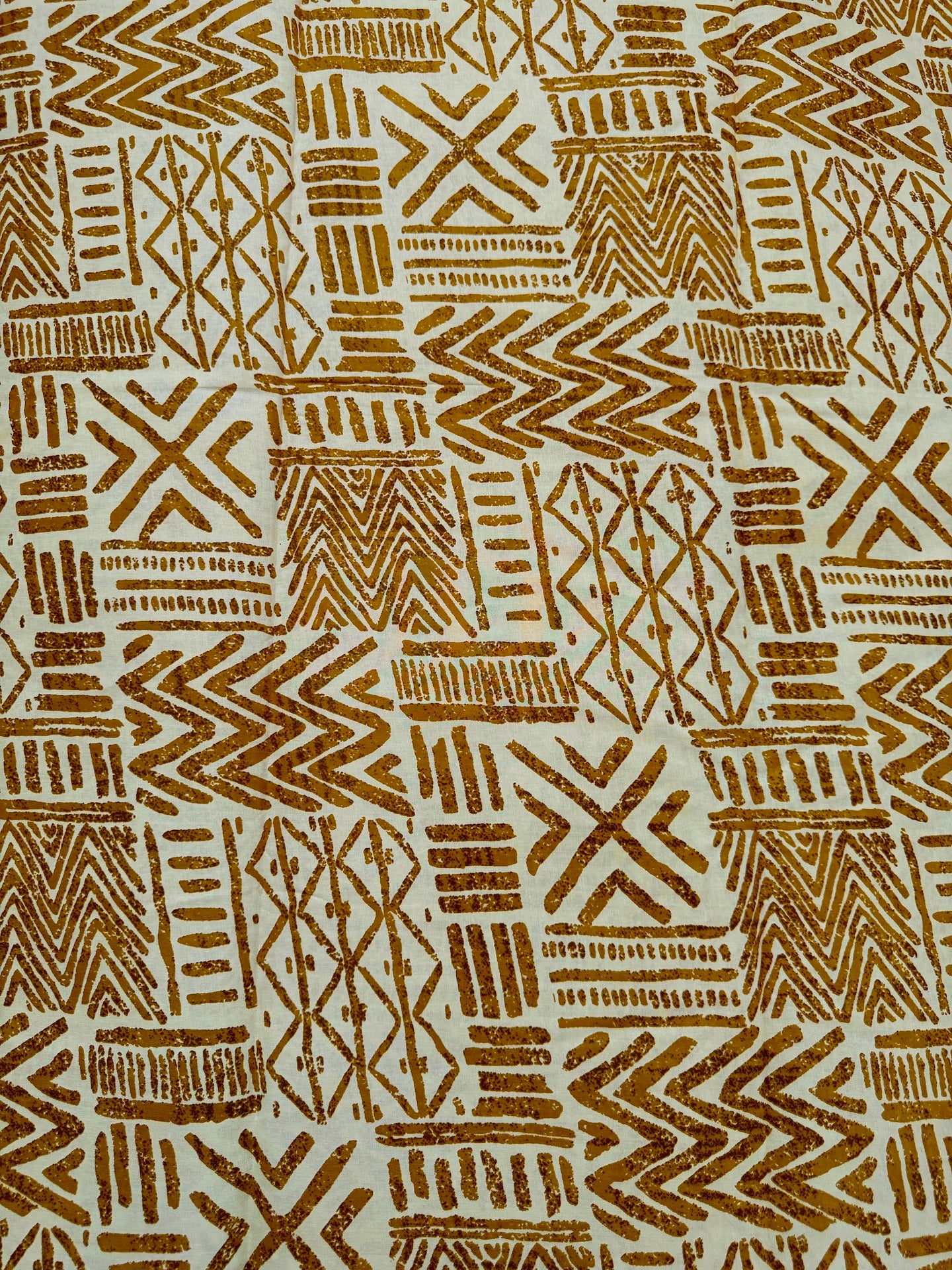Patterned fabric with brown geometric designs on a beige background