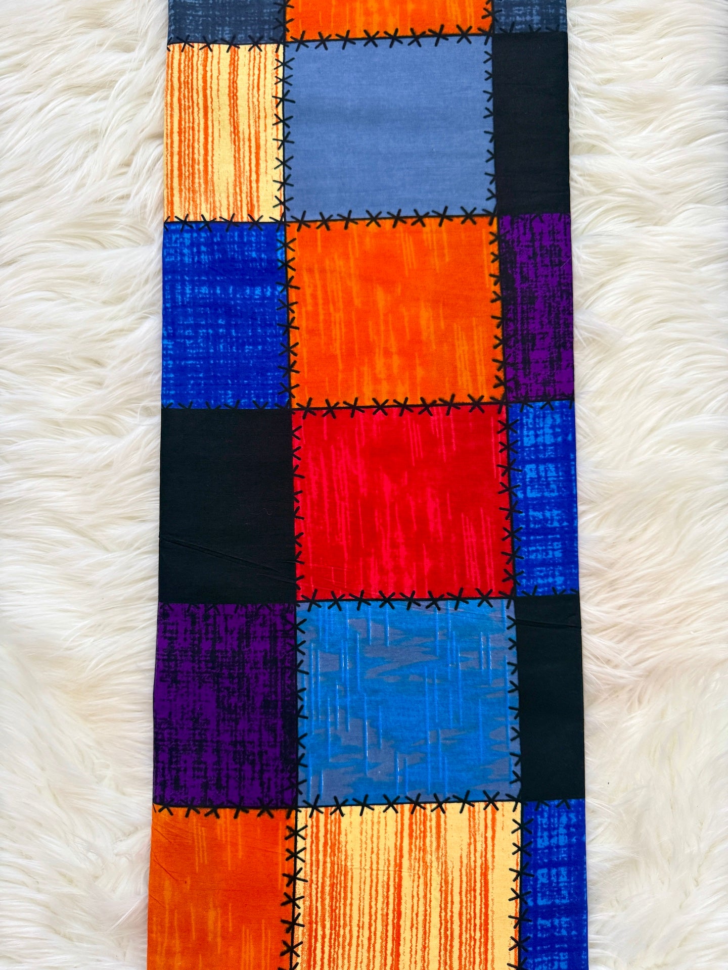 Colorful patchwork fabric on a white textured surface
