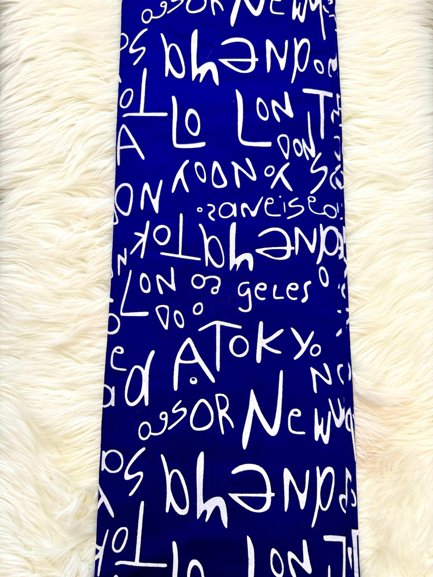 Blue scarf with white text on a fluffy white background