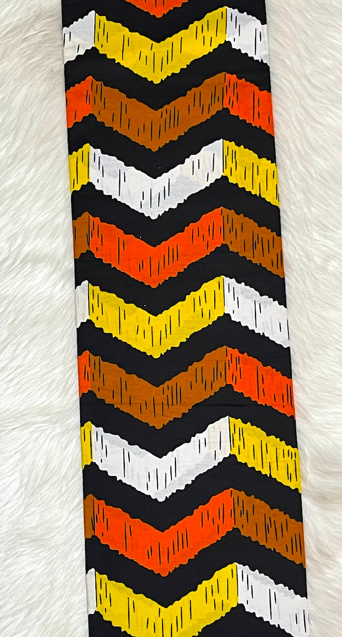 Tie with black, orange, and yellow chevron pattern on a white background