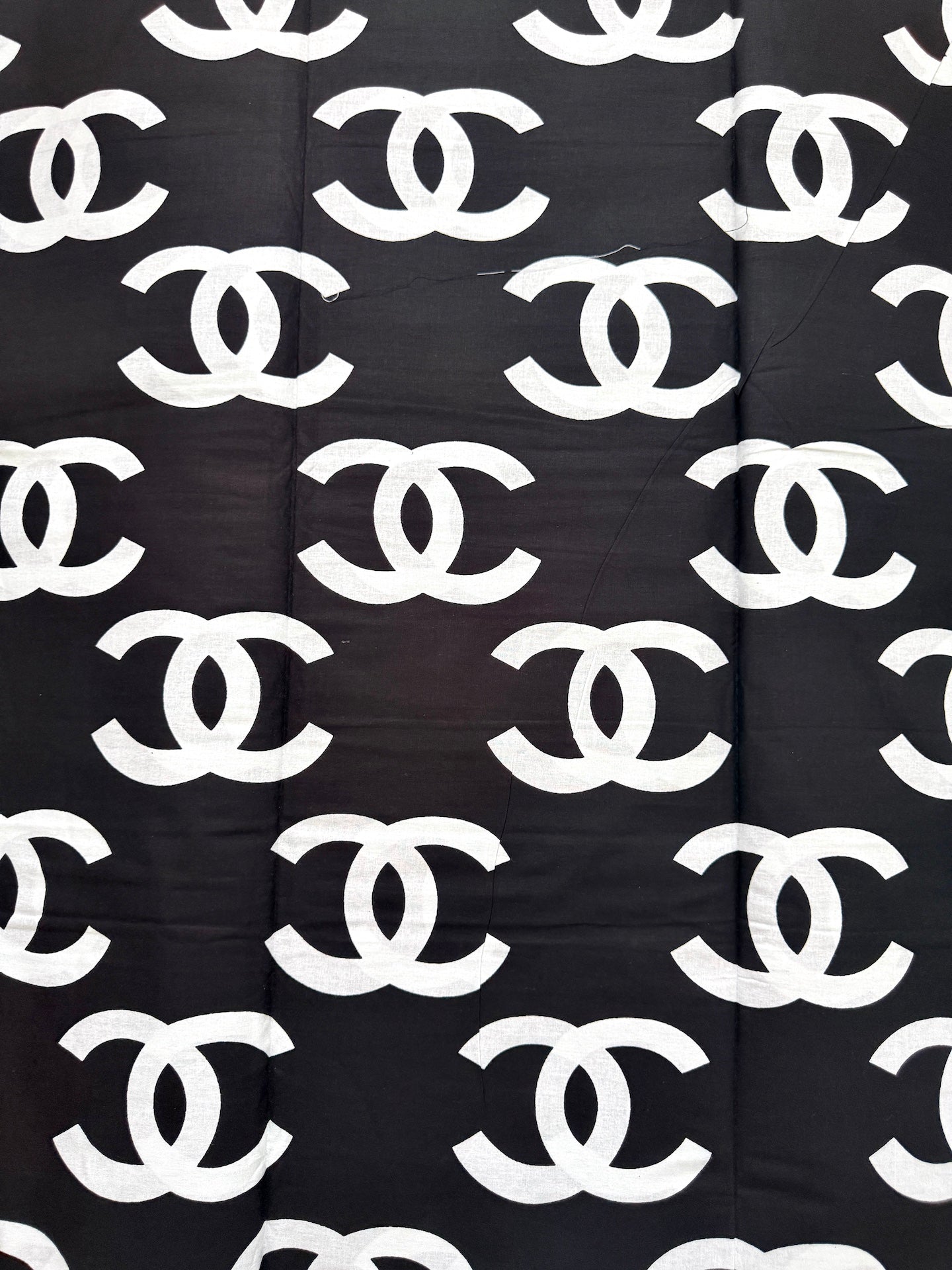 Black fabric with white Chanel logo pattern